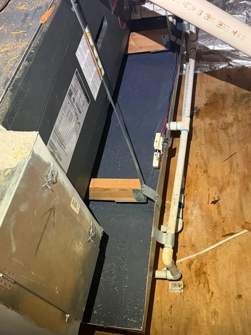 Overhead view of the sealed drain pan, the repaired condensate line, and the emergency float switch