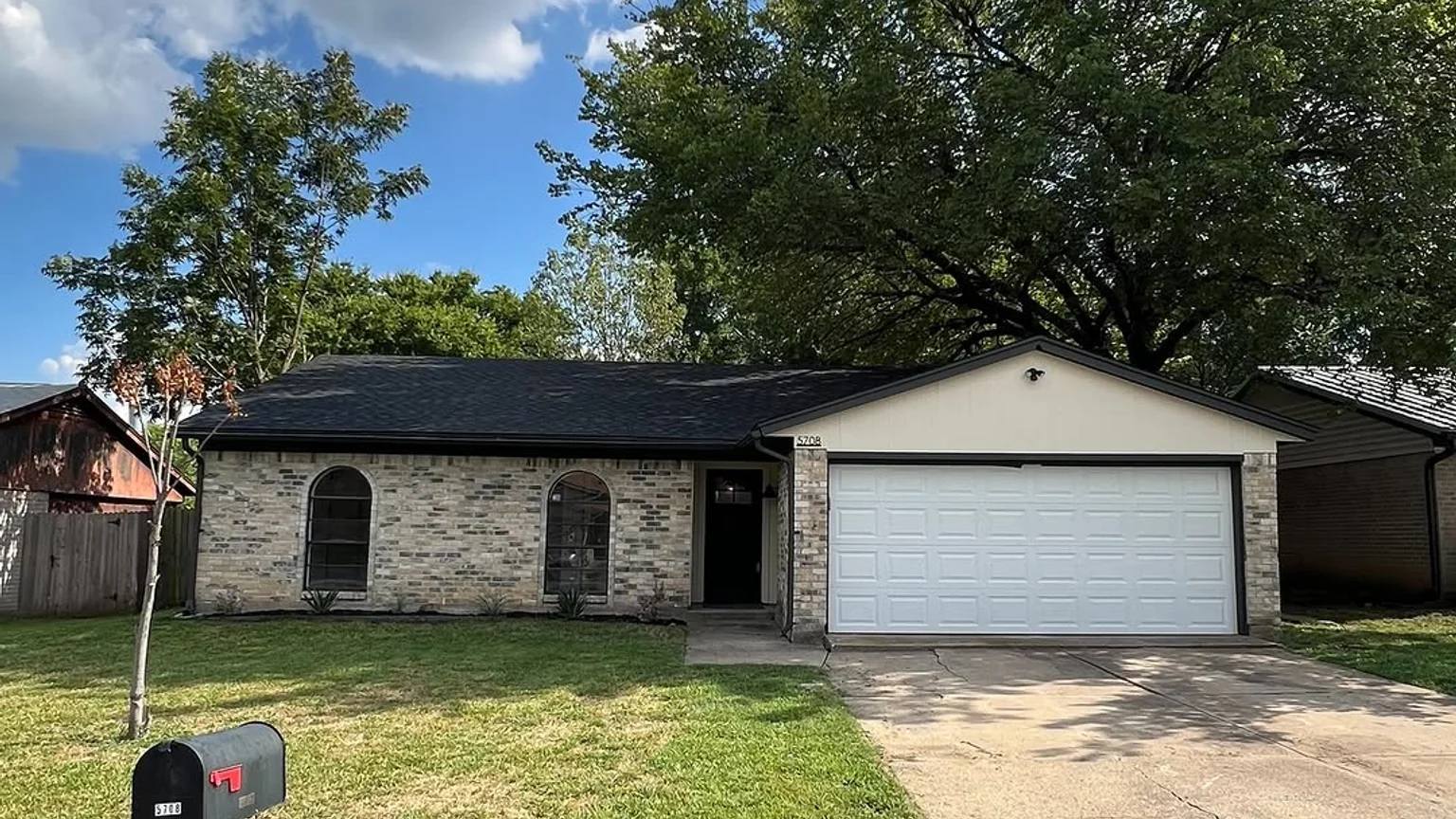 Lantern exterior project with freshly painted white trim, fascia, and garage door on a Dallas-Fort Worth brick home